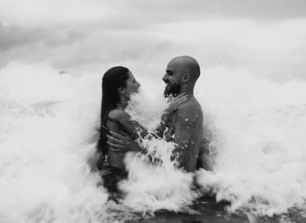 couple playing with ocean waves