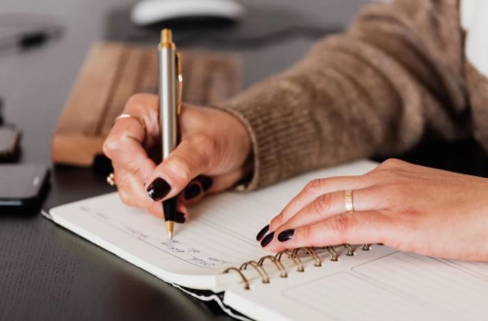 woman writing on journal