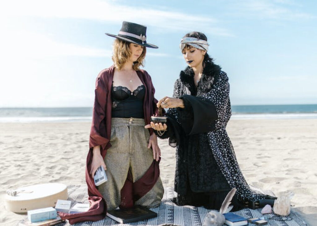 two women doing rituals on the beach